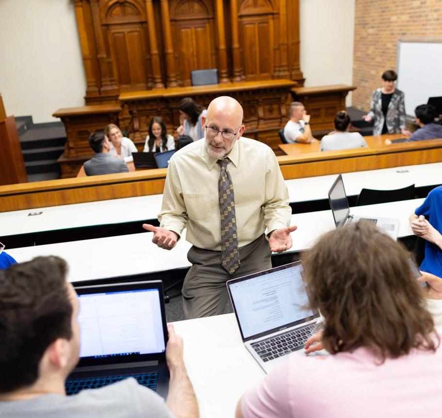 Faculty in discussion with students in classroom